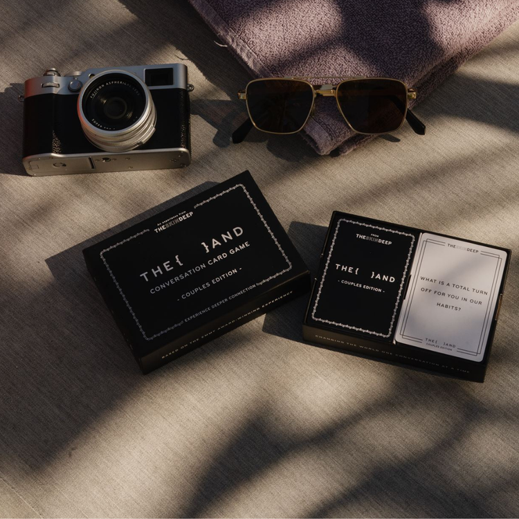 Camera, sunglasses, and 'The And' card decks on a textured surface